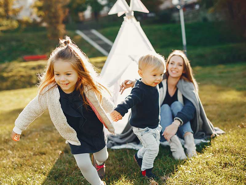 mother playing with her children outside